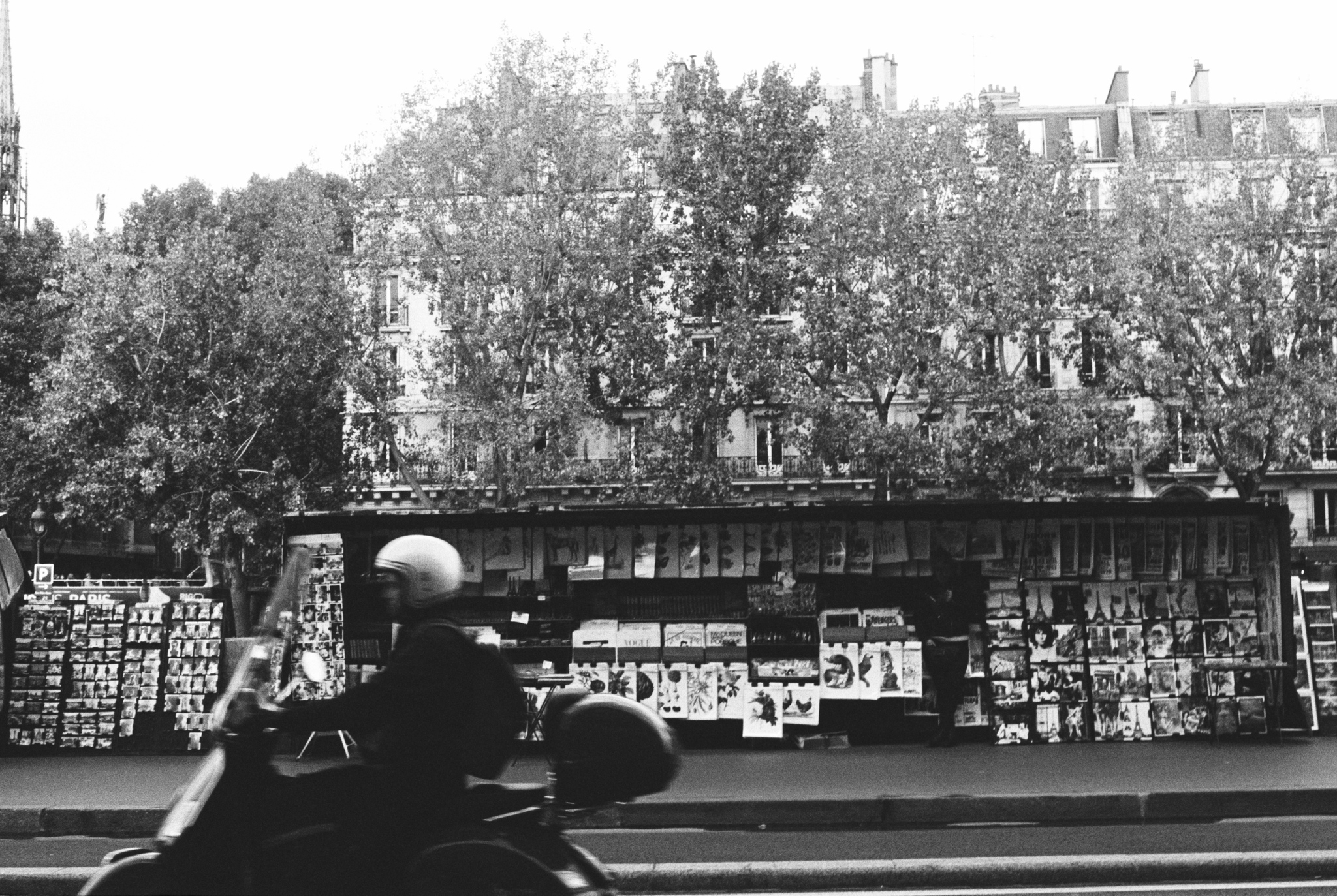 A book and art stand along the Seine river in Paris, France shot on black/white film.