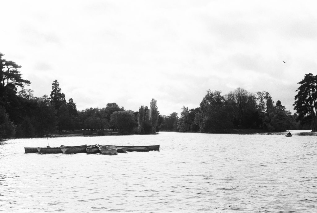 A lake and park in Paris, France with canoes to rent. Photographed on black/white film by Holly Michon Photography.