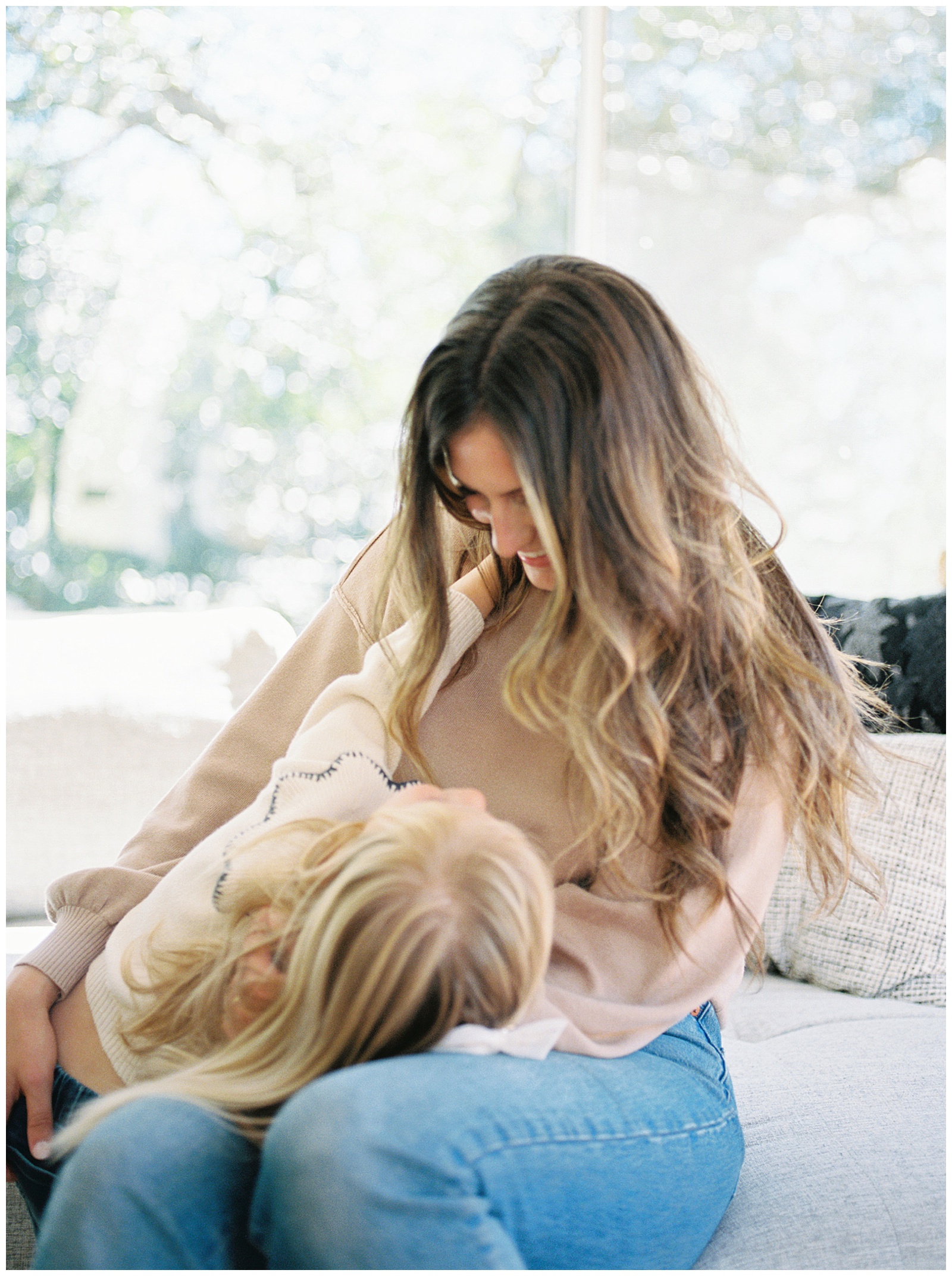 Mom plays with her daughter for candid photos in their home during their family session by Holly Michon Photography
