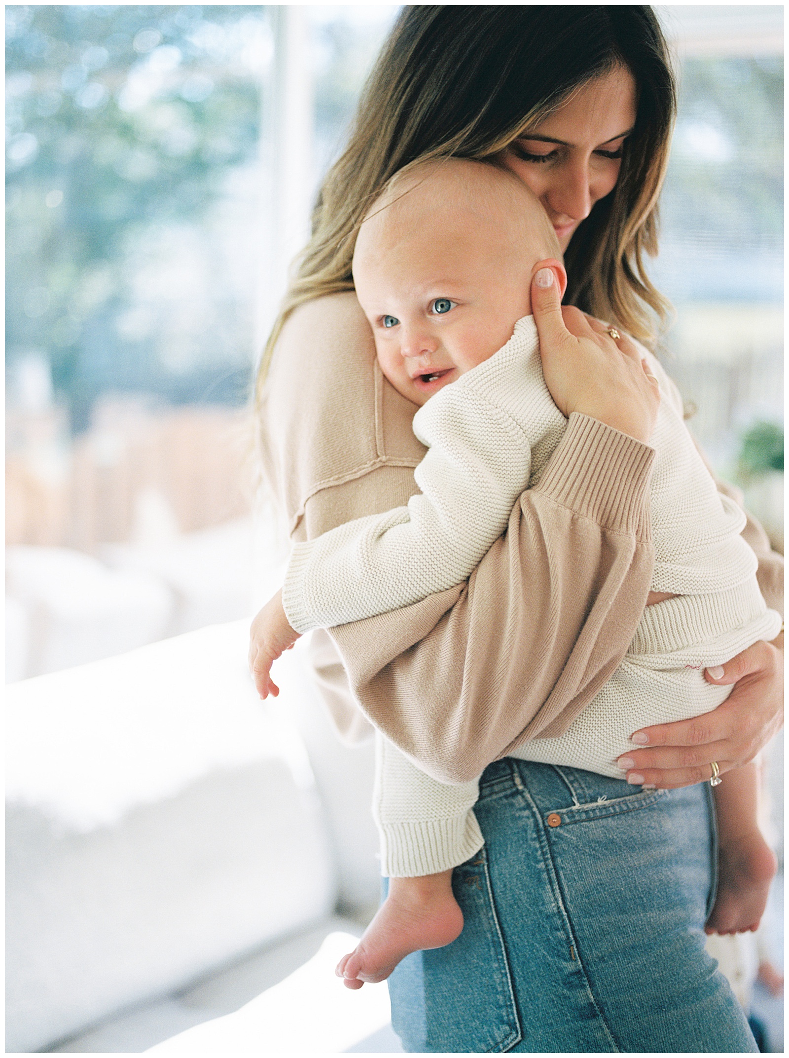 Mom snuggles her baby boy close in her arms for professional light filled and emotional family photos in Knoxville, TN