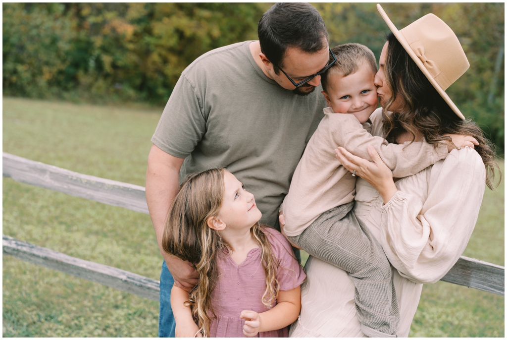 Adorable family snuggle together outdoors during their fall family session by Holly Michon Photography. 