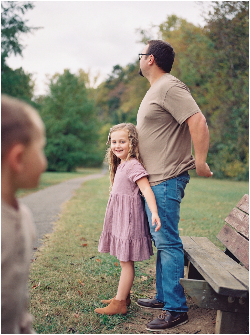 Sweet little girl leans on her dad smiling. Image by Holly Michon Photography