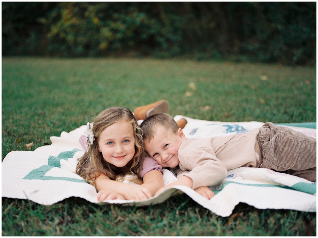 Brother and sister tease and smile fondly at each other during their family session in the fall. Knoxville, TN