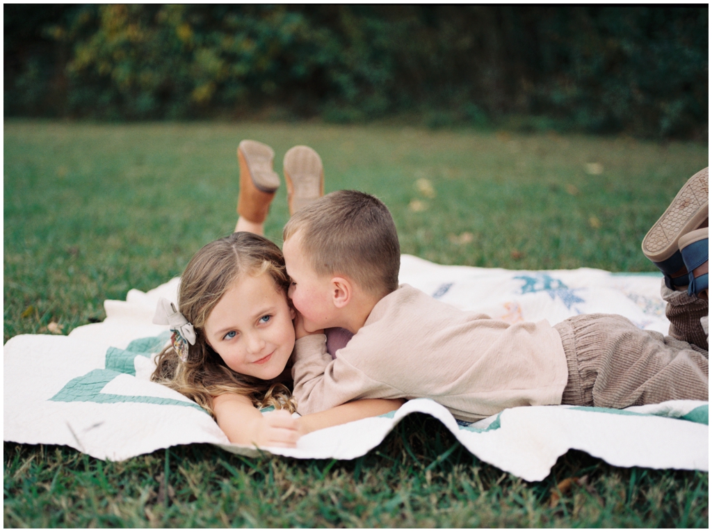 Brother and sister tease and smile fondly at each other during their family session in the fall. Knoxville, TN