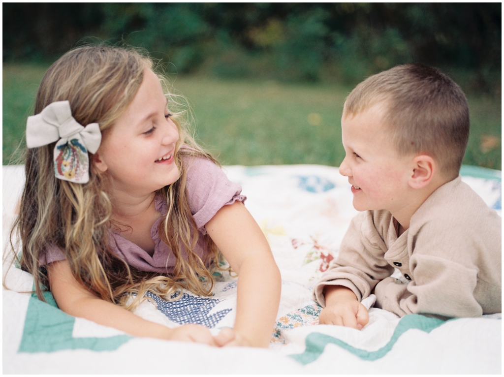 Brother and sister tease and smile fondly at each other during their family session in the fall. Knoxville, TN