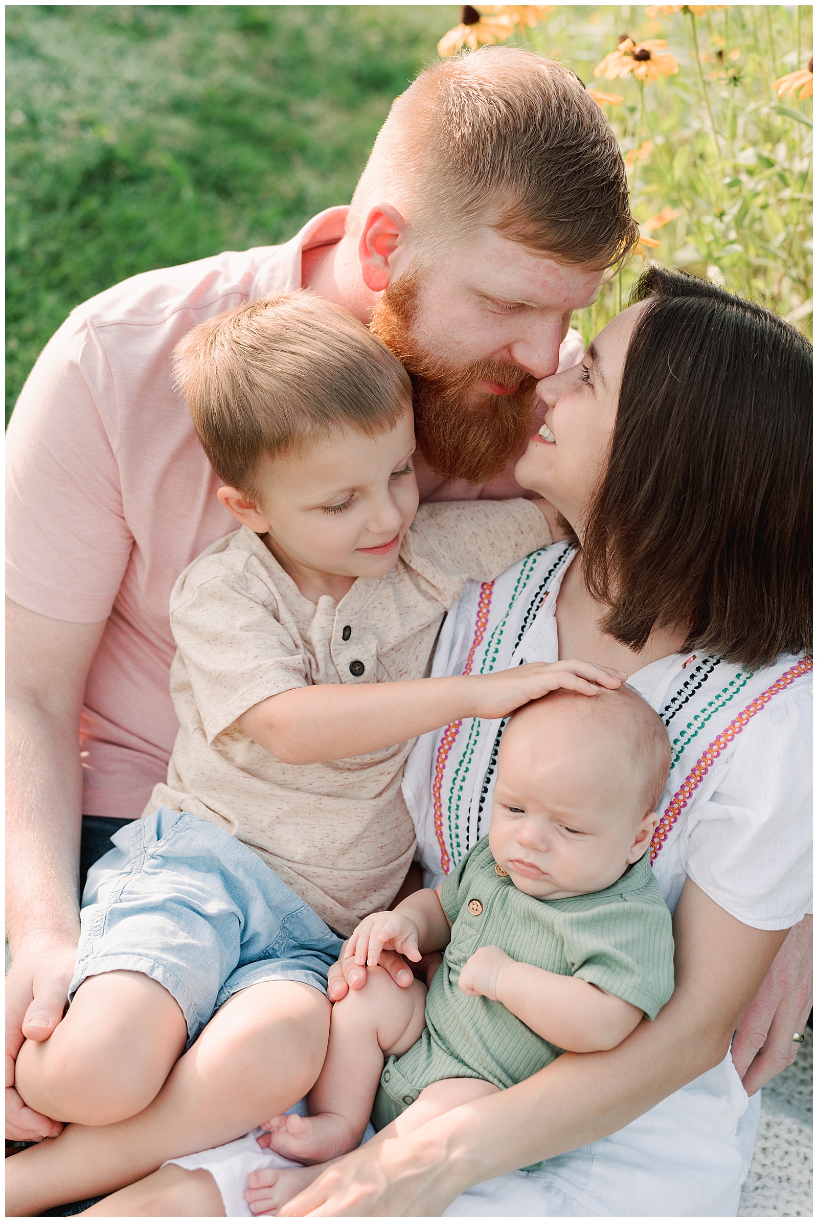 Knoxville family of four cuddle outdoors at UT Gardens.