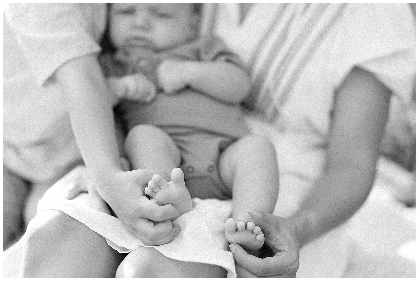 Black and white image of mom and son holding newborn in Knoxville, TN.