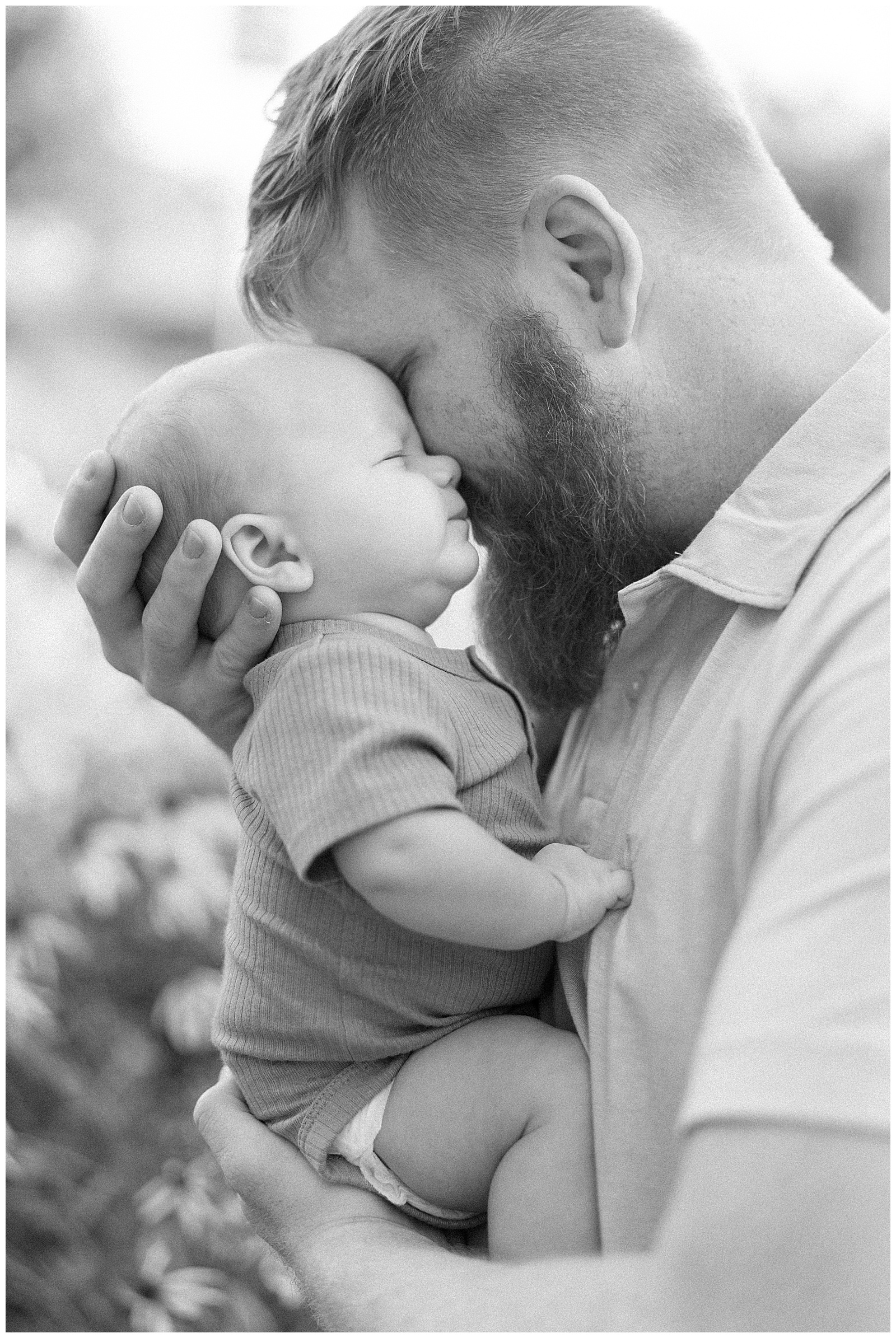 Black and white image of a dad holding son in an emotional embrace at UT gardens in Knoxville, TN.