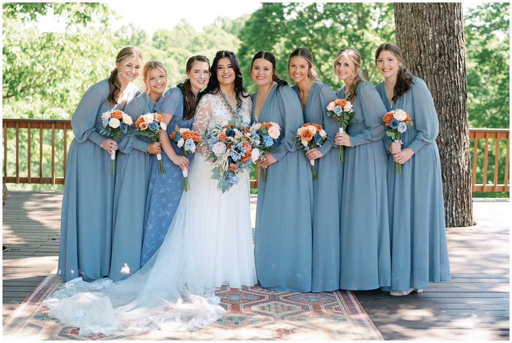 Beautiful bride surrounded by smiling bridal party in Knoxville spring wedding.