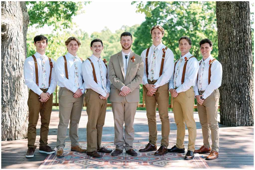 Groom surrounded by groomsmen in colorful Knoxville spring wedding. 