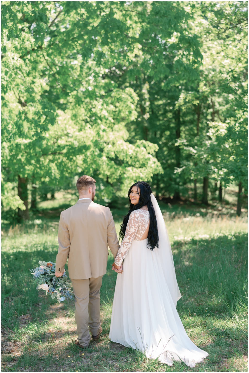 Bride looks over shoulder in East Tennessee meadow.