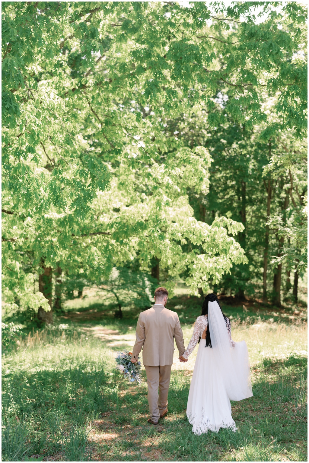 Stunning image of bride and groom walking in sunny meadow in spring Knoxville wedding.