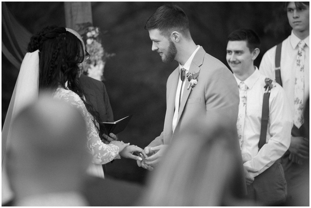 Black and white image of the exchanging of rings during ceremony at Knoxville spring wedding.