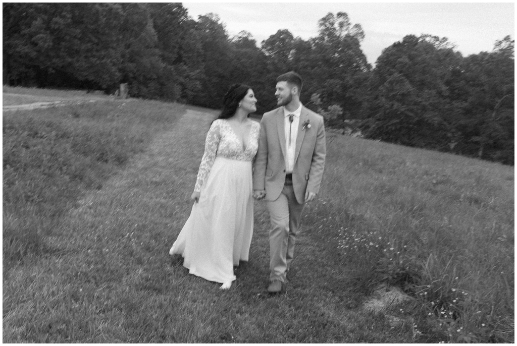 Black and white motion photo of bride and groom walking together.