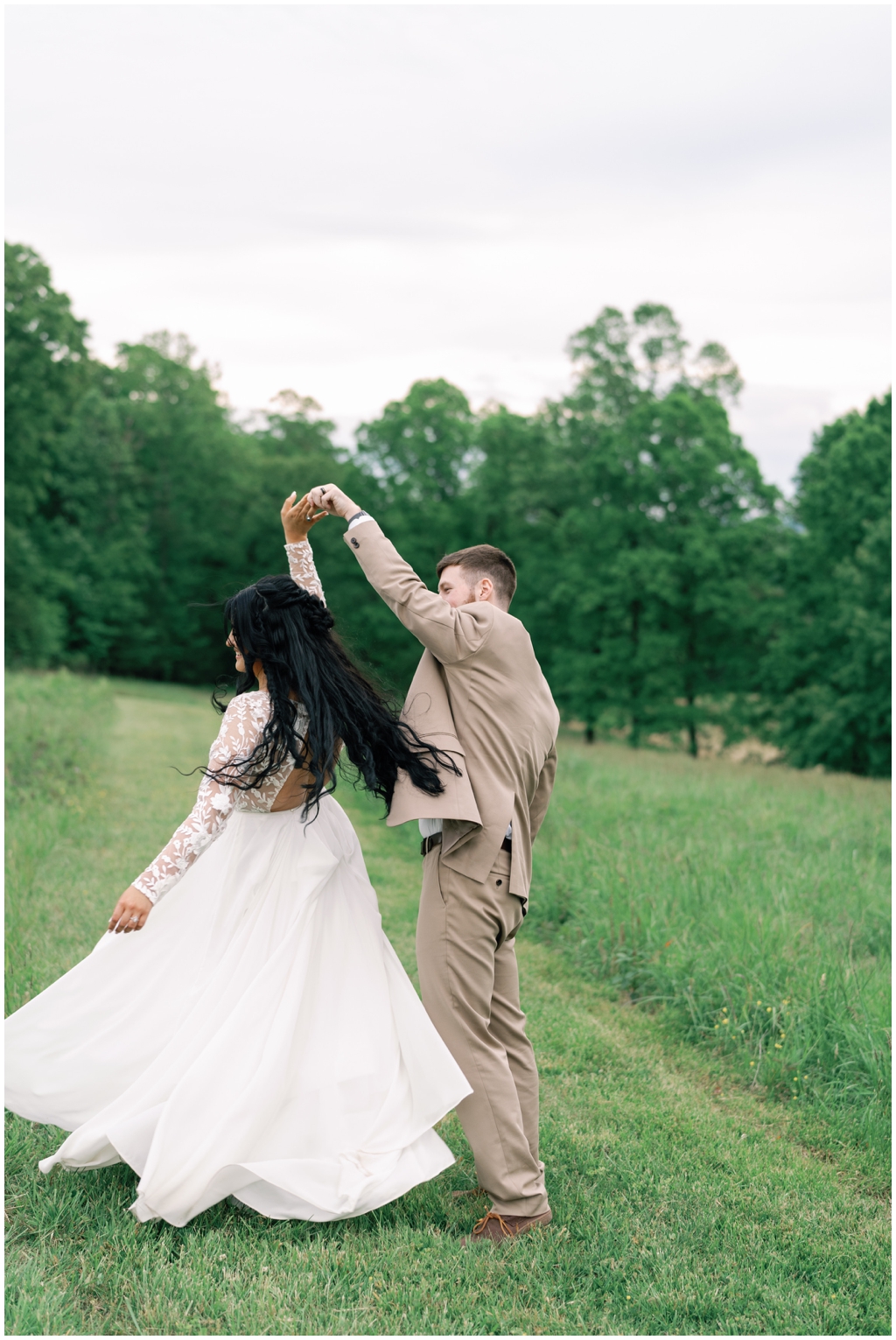 Groom spins bride in sunny field during bright and colorful Knoxville, TN spring wedding.