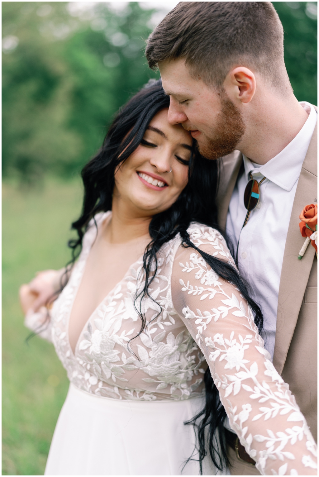 Groom hugs bride from behind in bright image of Knoxville, TN wedding.