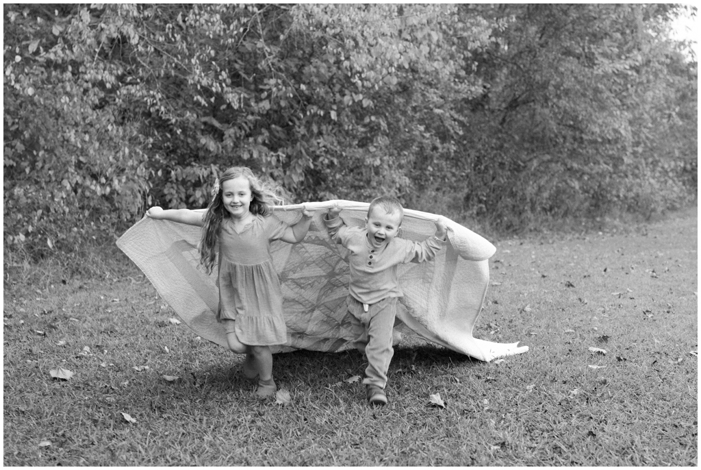 Black and white image of brother and sister playing in park in Knoxville, TN.