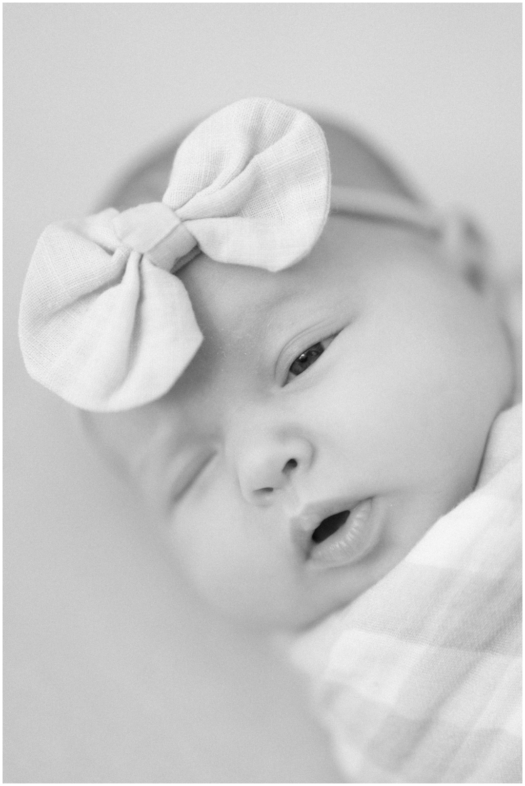 Black and white image of a swaddled newborn in quaint and intimate photoshoot in Knoxville, TN.