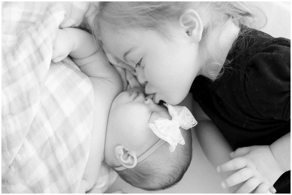 Black and white image of snuggly sister duo during newborn session in Knoxville, TN.