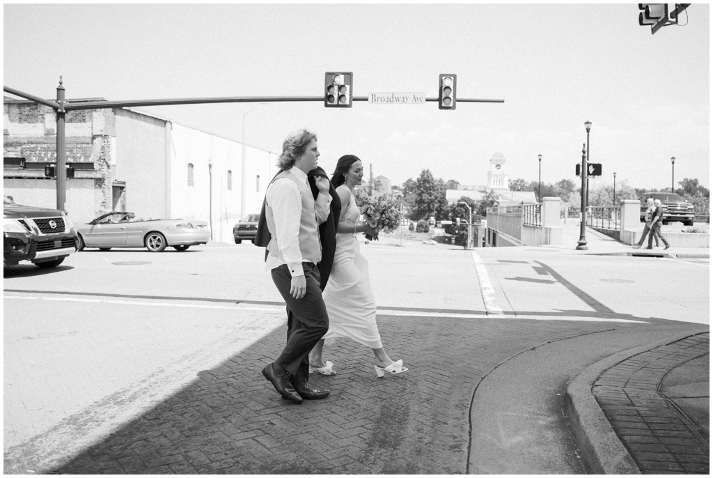 Bride and groom walk in downtown Maryville in black and white image.