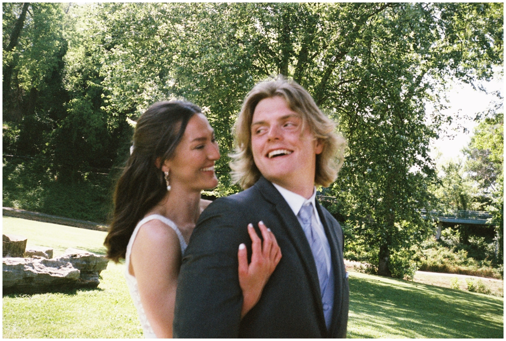 Bride hugs groom from behind in Maryville classy summer wedding.