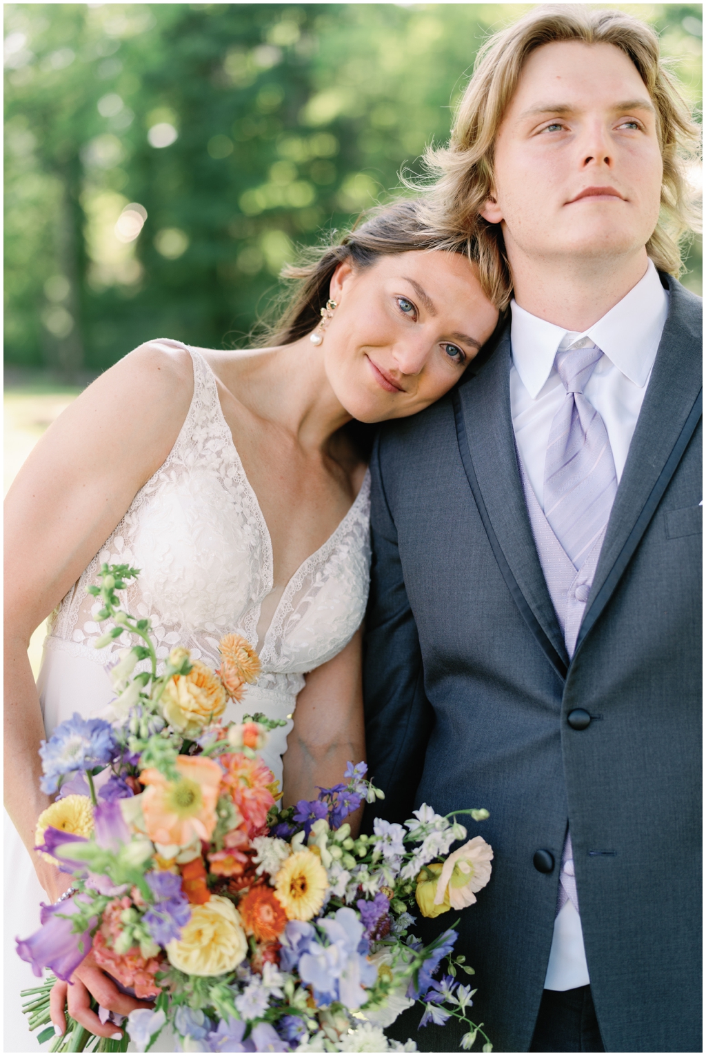 Bride leans on grooms shoulder at Maryville park in bright image.