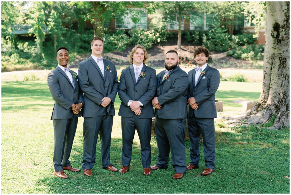 Groom and groomsmen pose together at park in Maryville, TN.