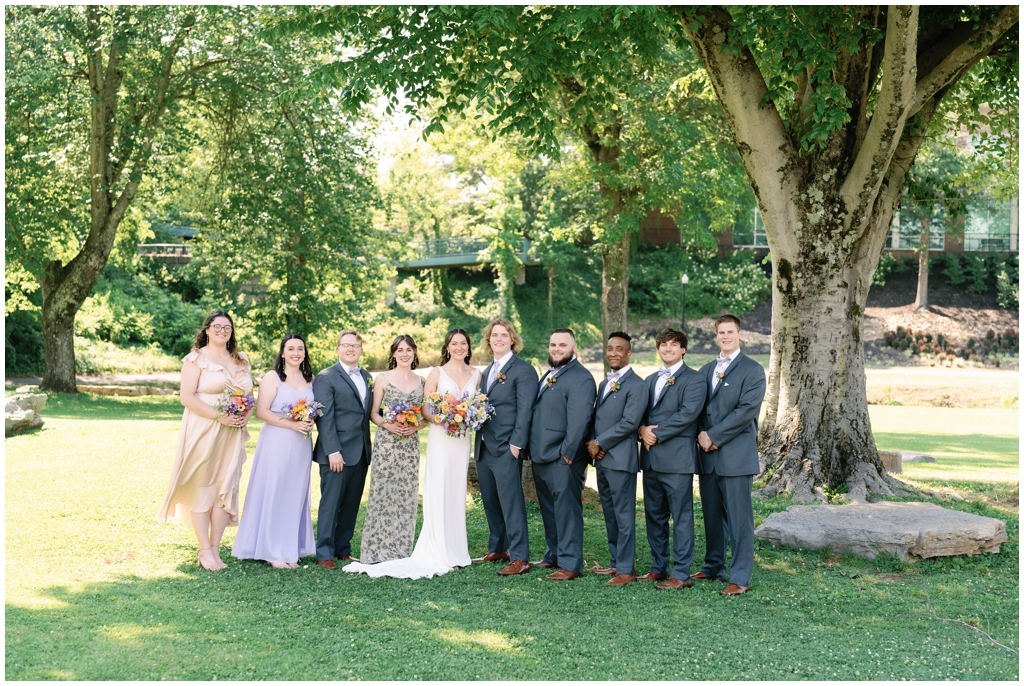 Wedding party poses together at Maryville park for classy summer wedding.