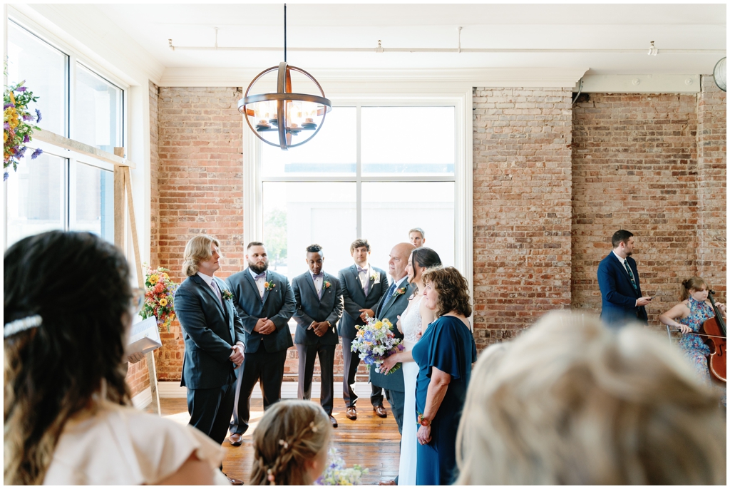 Groom watches bride walk down aisle at classy and romantic wedding in Maryville, TN.