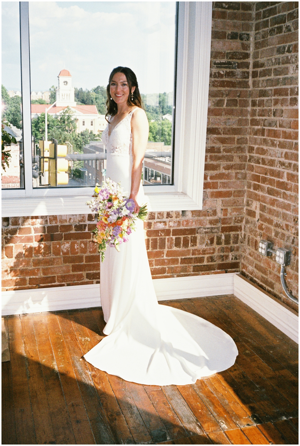 Film photo of beautiful bride in front of window during classy and romantic summer Maryville wedding.