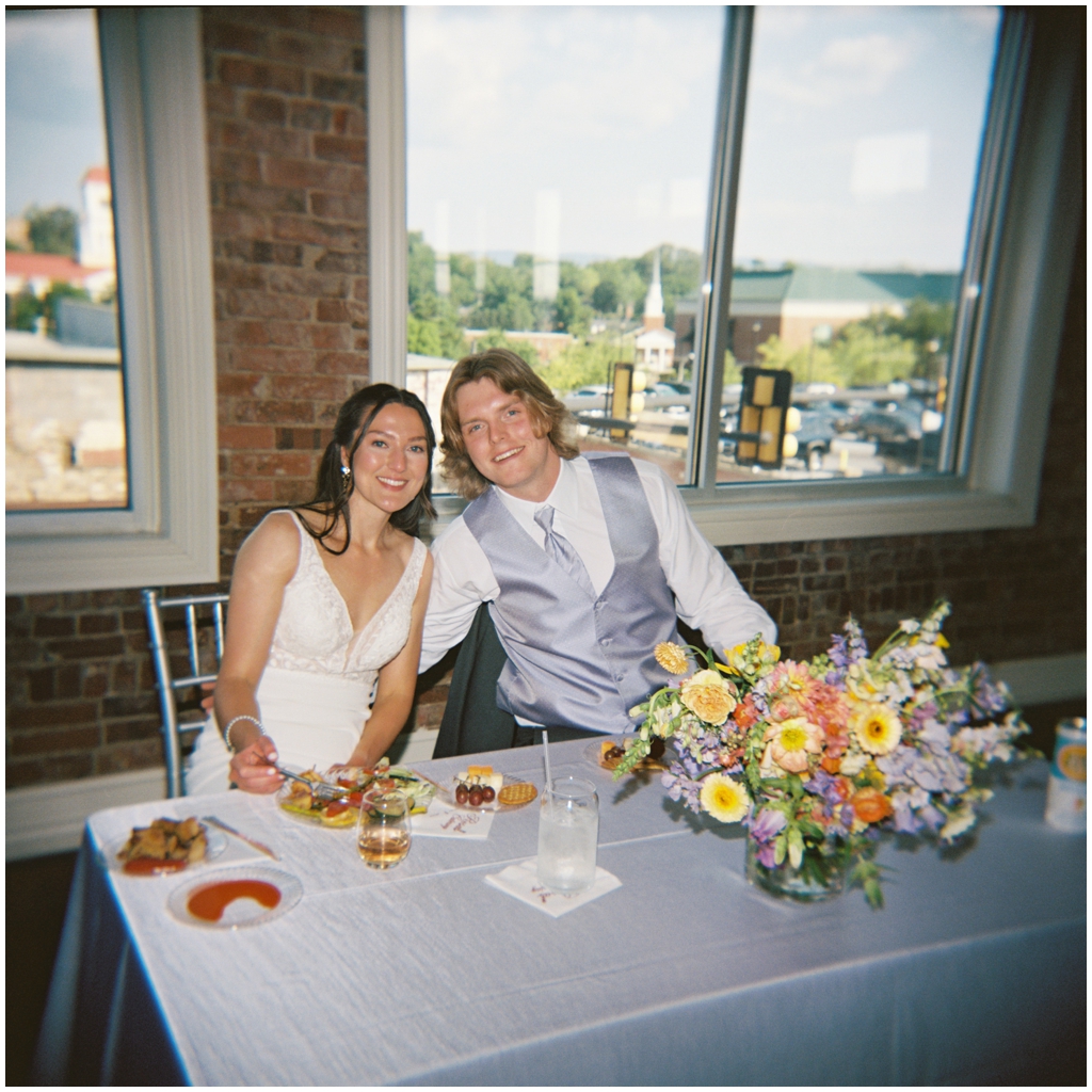 Film image of bride and groom eating at reception in Maryville, TN.