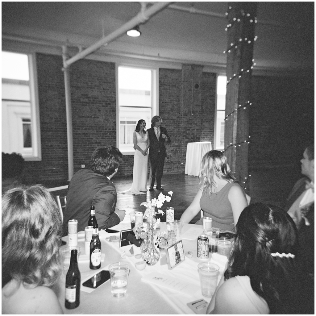 Black and white film photo of bride and groom giving speech at classy and romantic wedding in Maryville, TN.