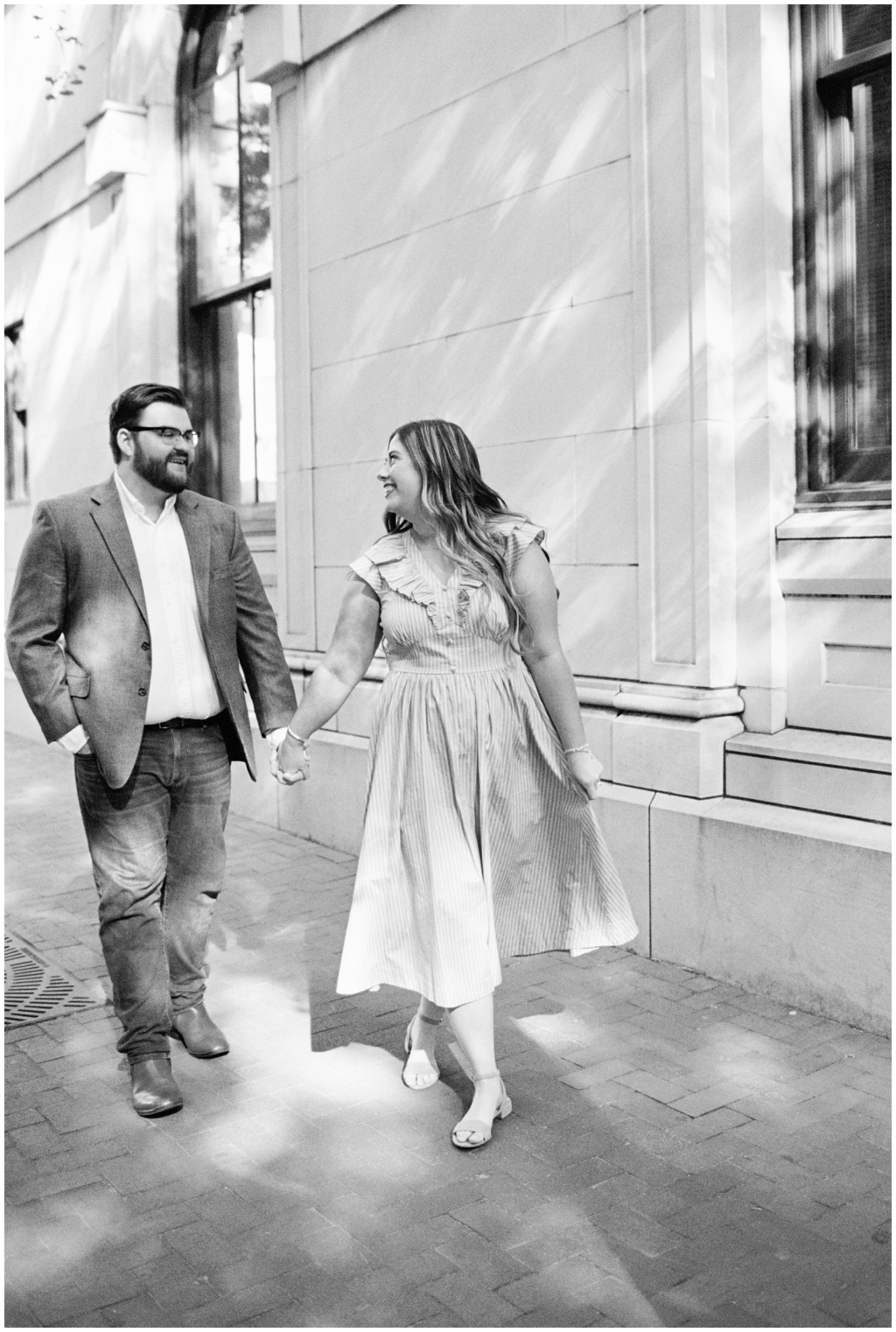 Black and white image of Ashley and Jackson strolling through downtown knoxville during dreamy anniversary session