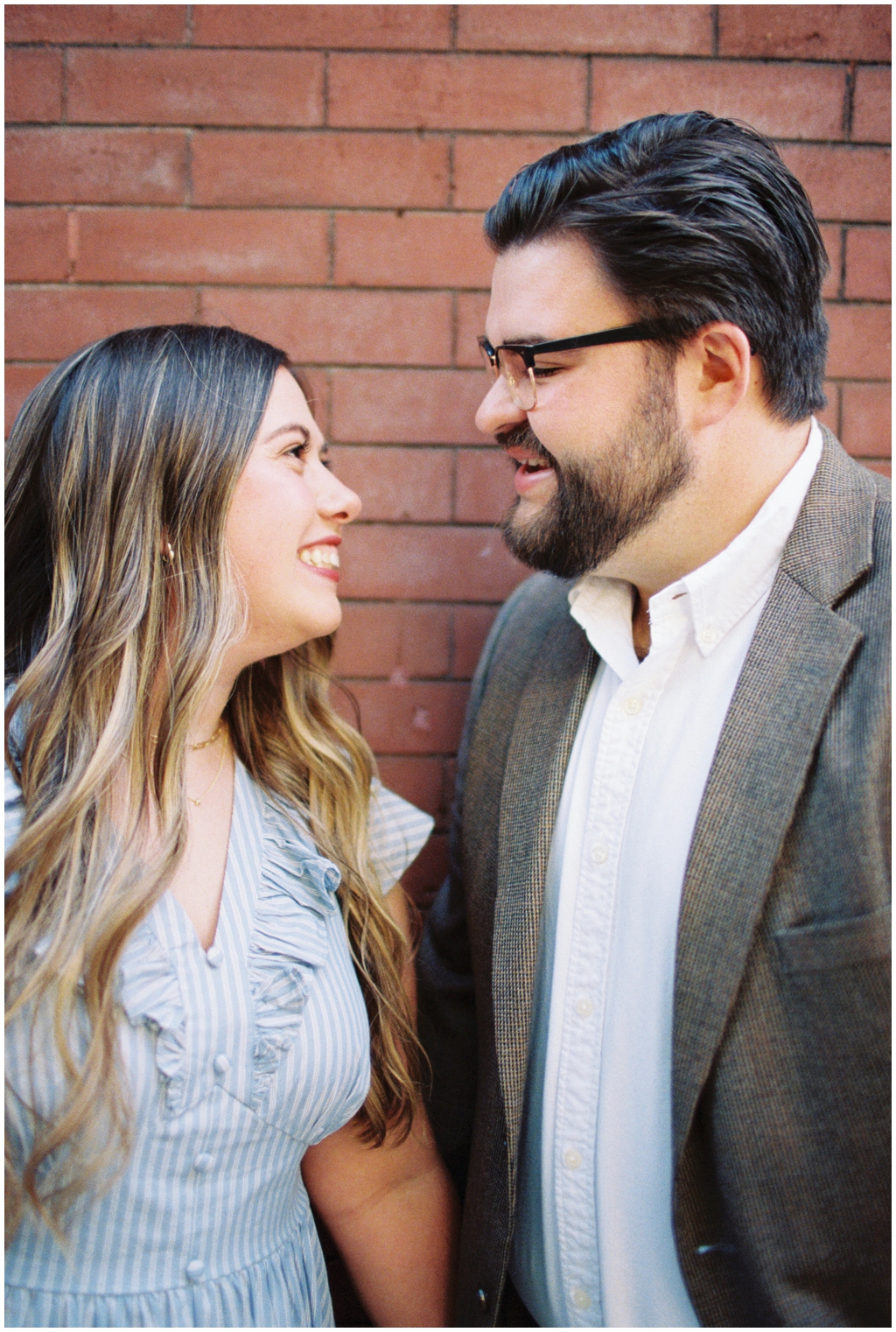 Husband and wife smile at each other during downtown knoxville anniversary session