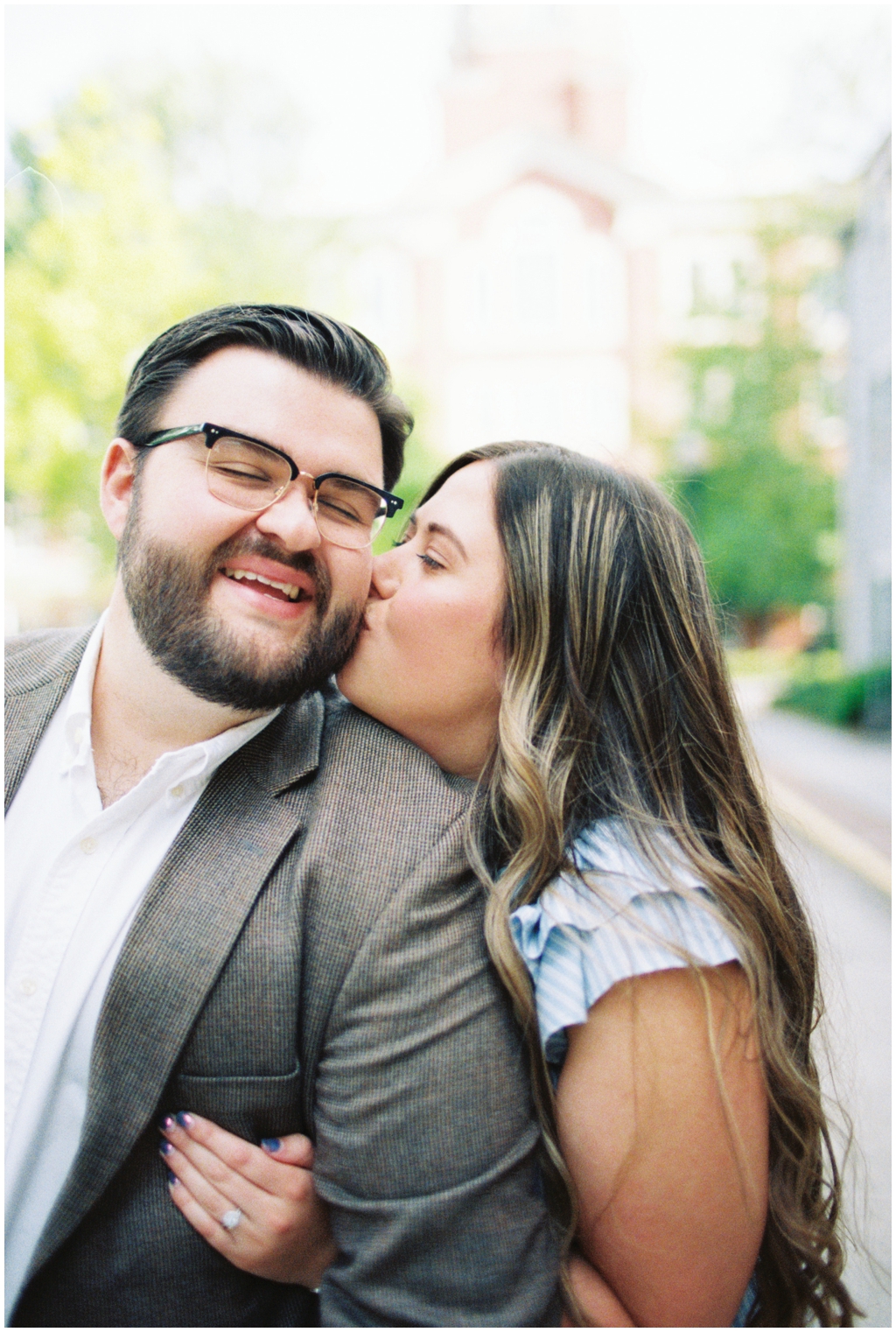 Ashley kisses her husband Jackson on the cheek during downtown anniversary session.