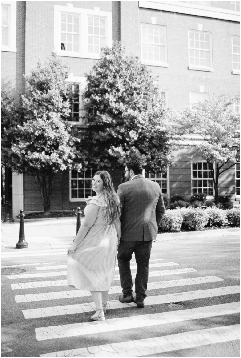 Black and white image of husband and wife walking through downtown knoxville