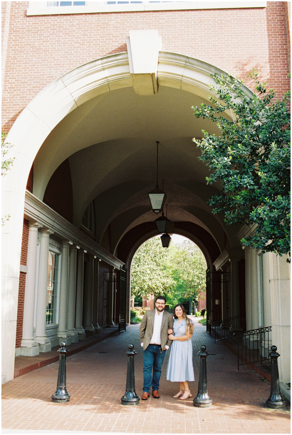 Ashley and Jackson pose together in front of downtown building for anniversary session