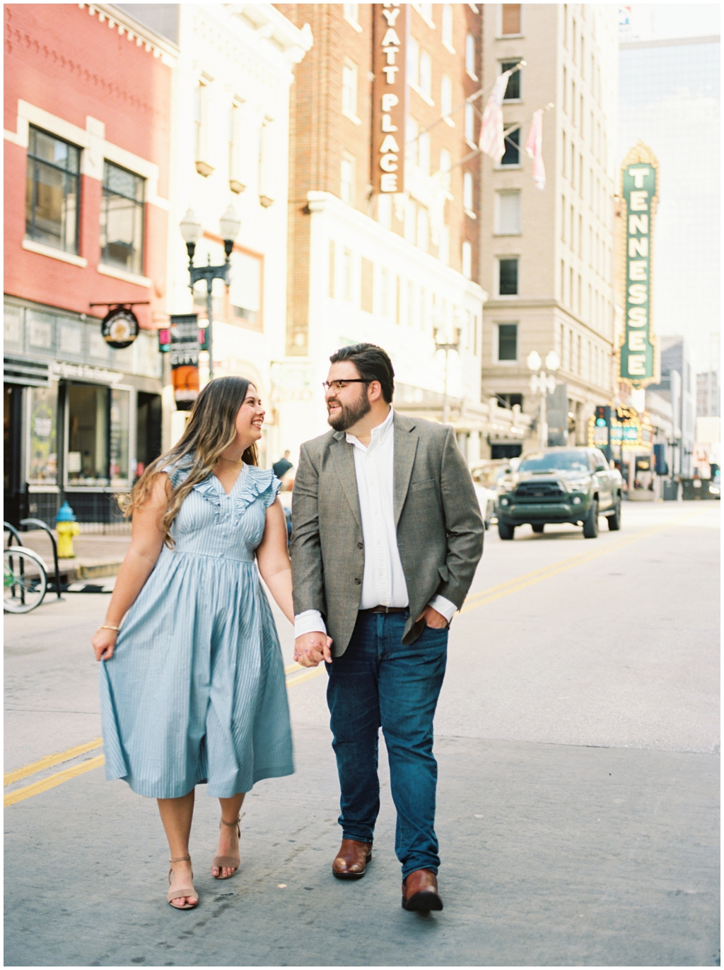 Husband and wife pose in front of the Tennessee Theater sign in downtown knoxville for anniversary session