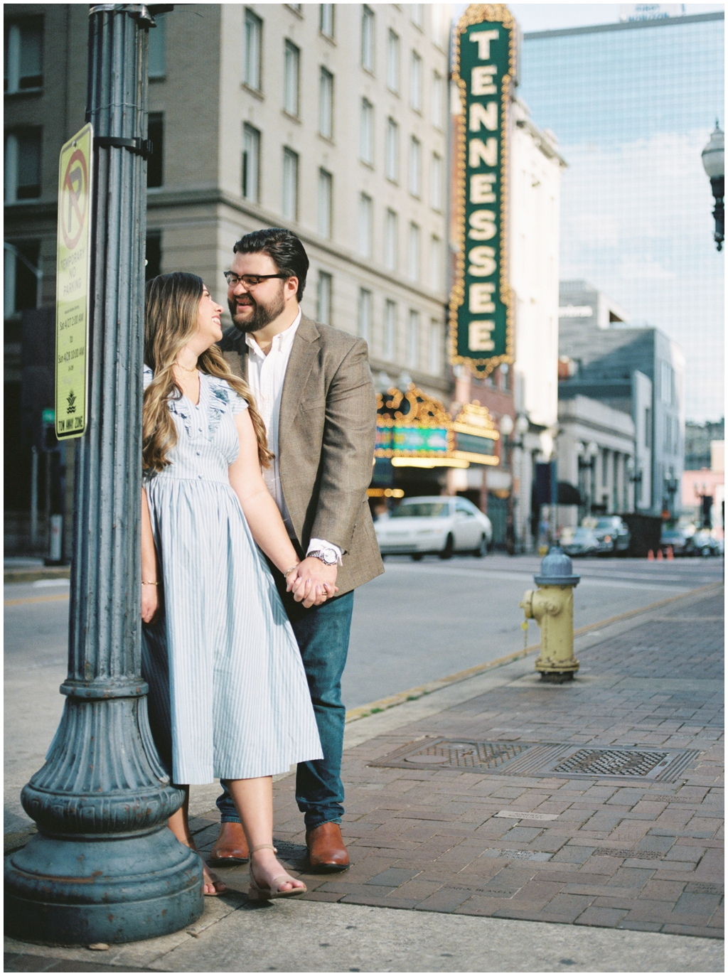 Husband and wife pose in front of the Tennessee Theater sign in downtown knoxville for anniversary session