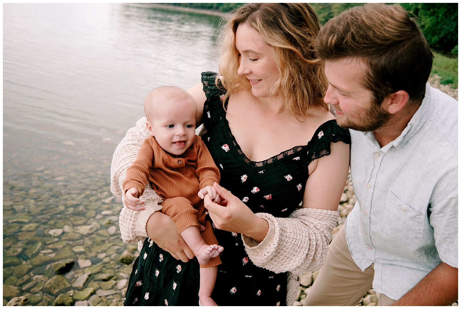 New family of three poses together for relaxed Lake Michigan family session