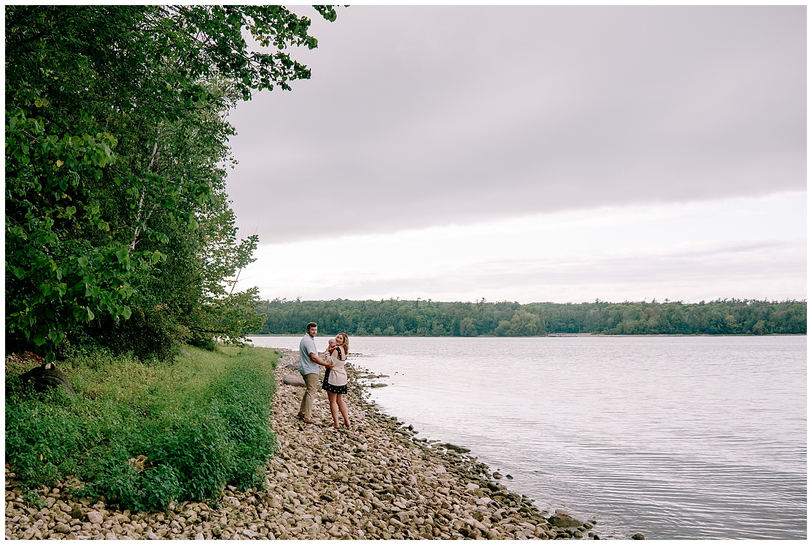 Family of three looks over their shoulders for relaxed and natural family session