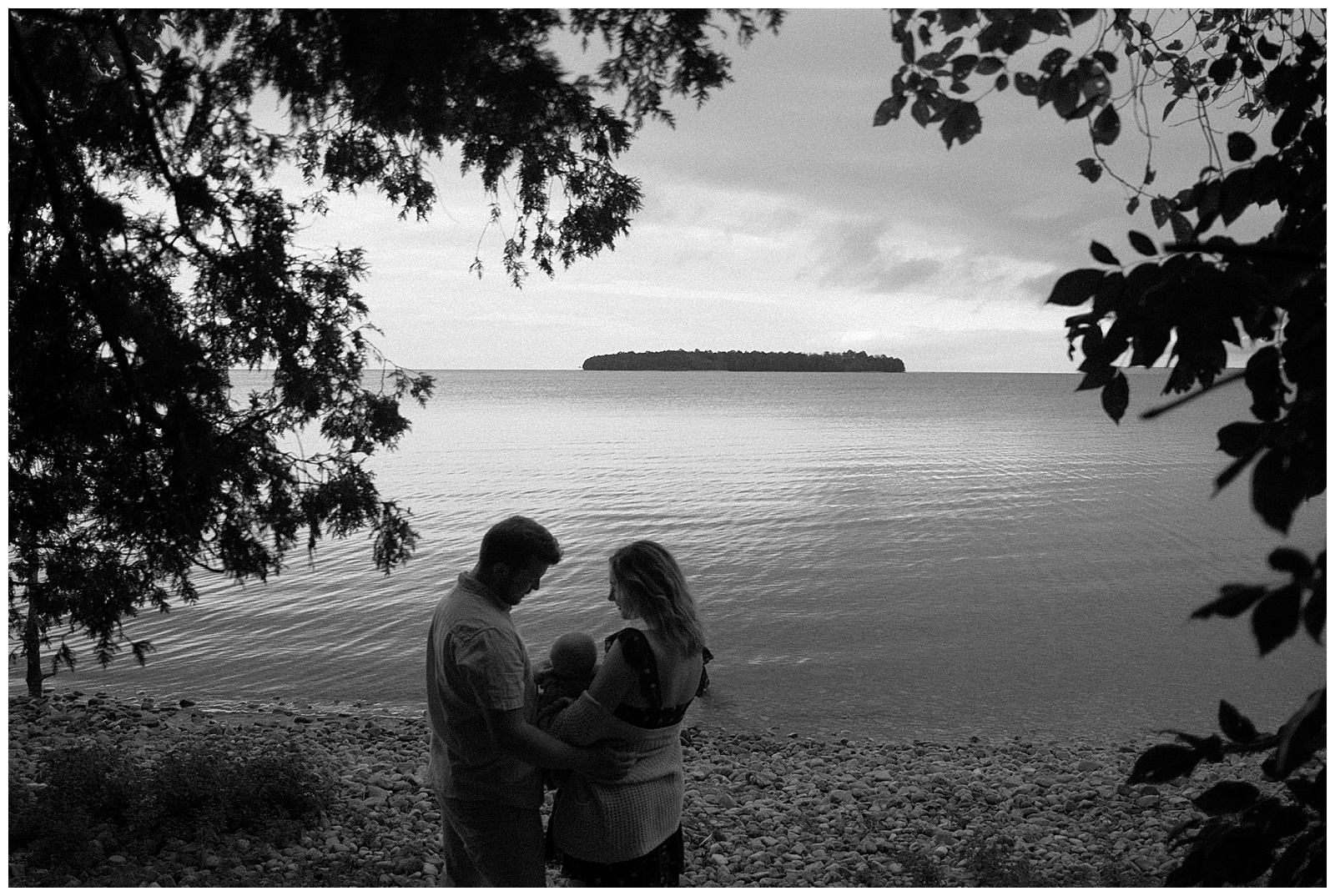 Black and white intimate image of beautiful family on the shores of a lake