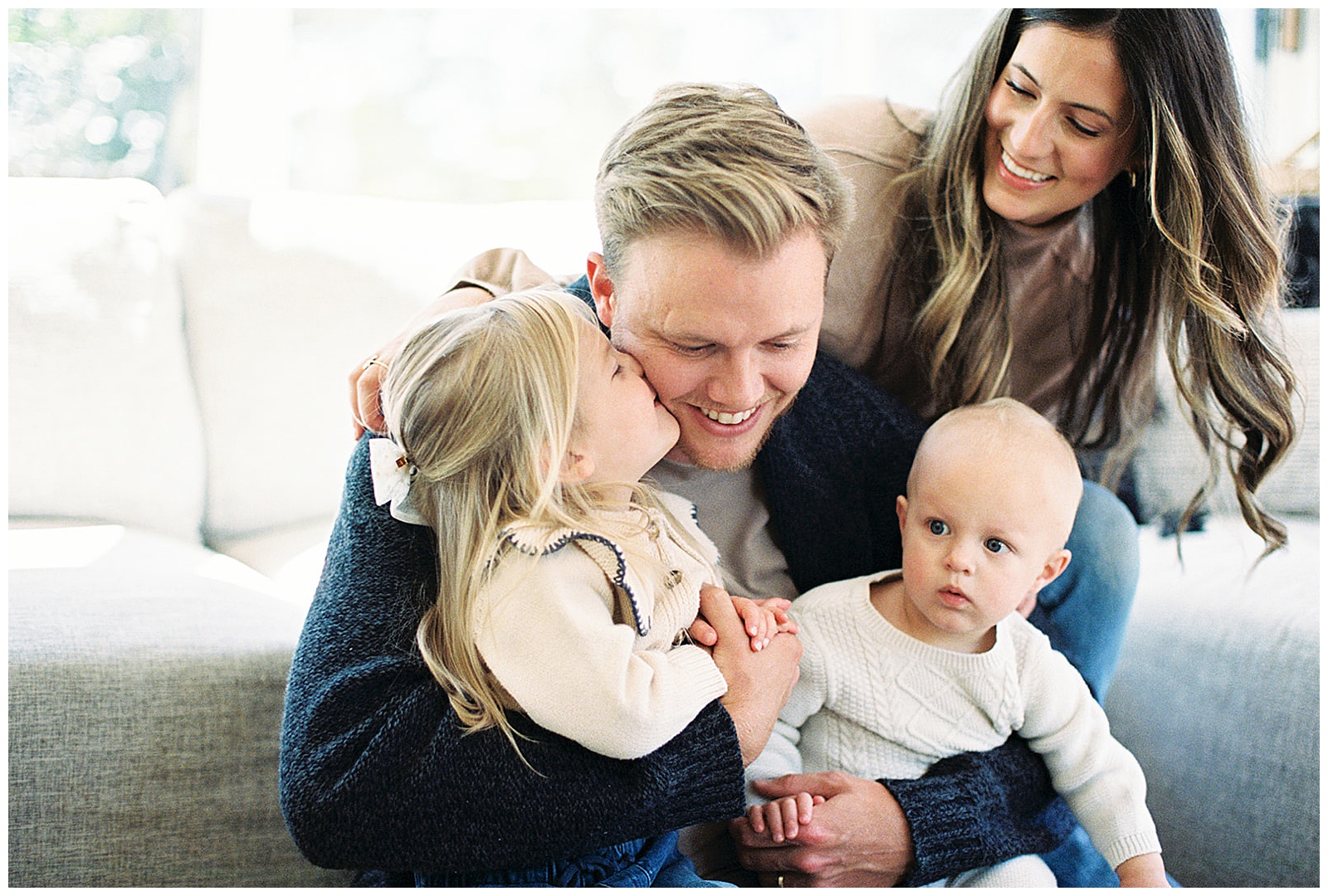 Family of four cuddles together for in-home lifestyle session