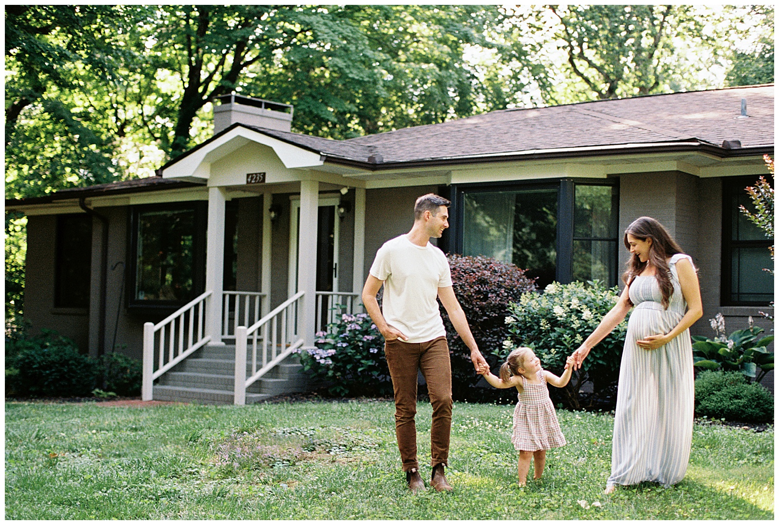 Family of three take a stroll in their backyard during Knoxville in-home lifestyle session