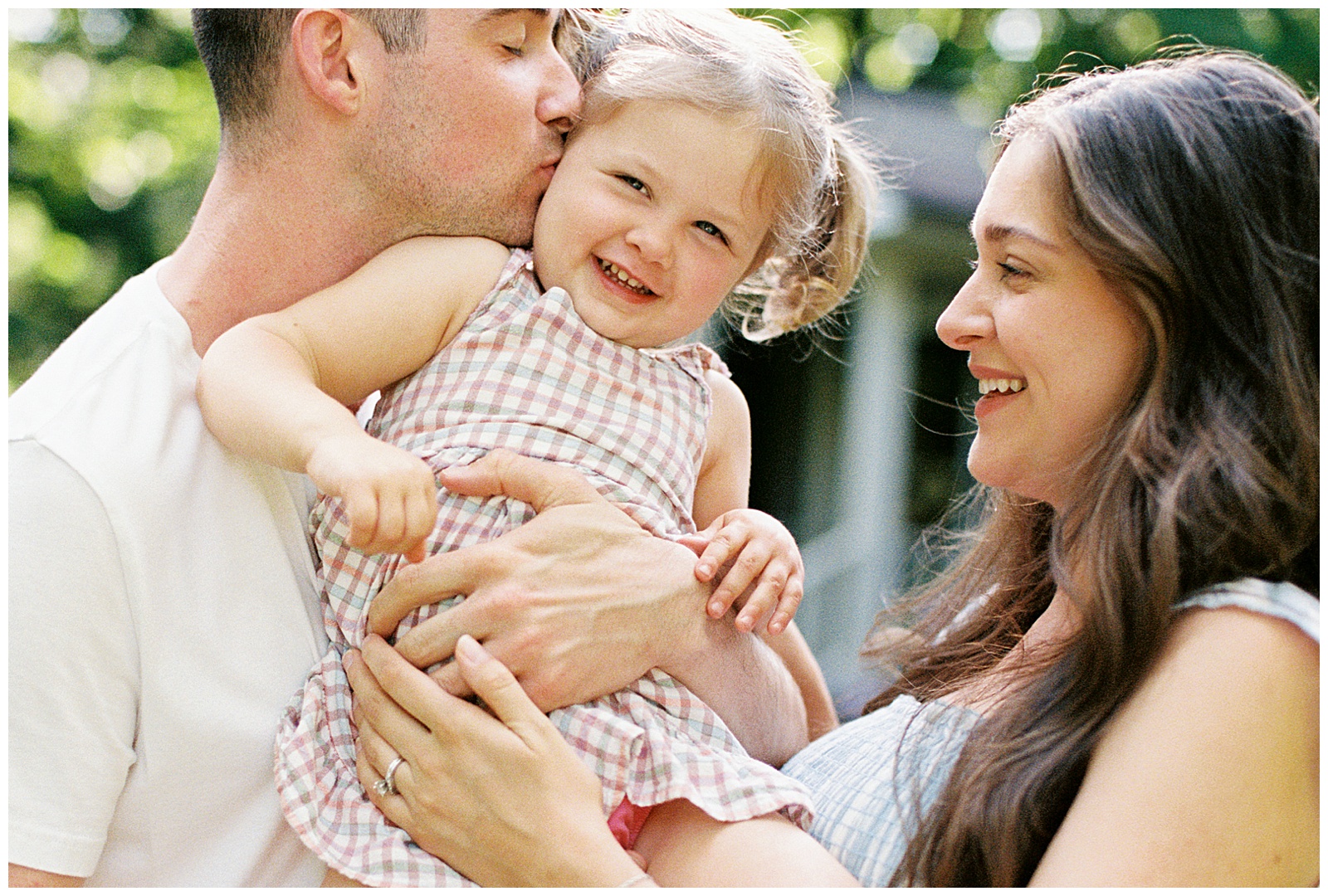 Family of three laugh together during Knoxville lifestyle maternity session