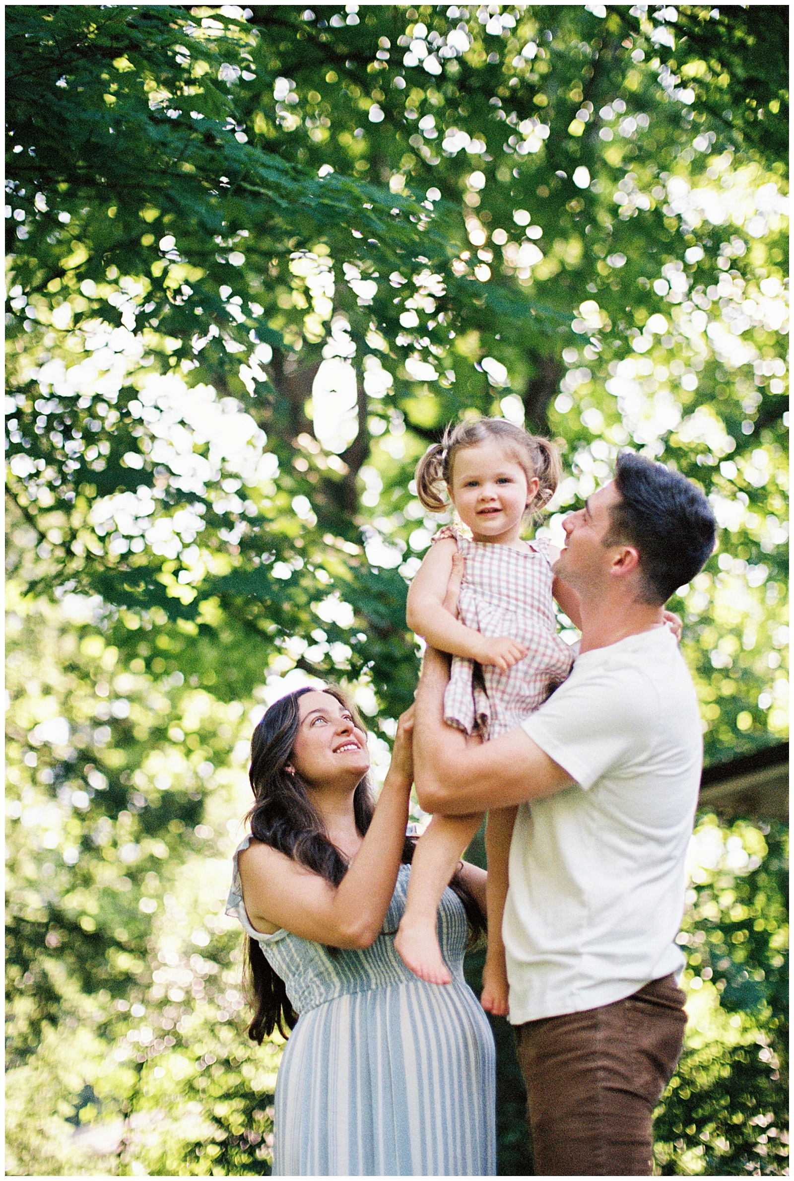 Dad lifts daughter up during end of summer maternity session