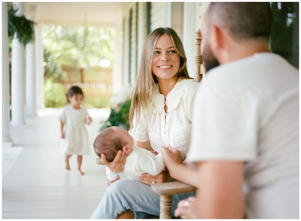 Newborn photography at home in Knoxville, TN with mom and dad cradling baby in their arms.