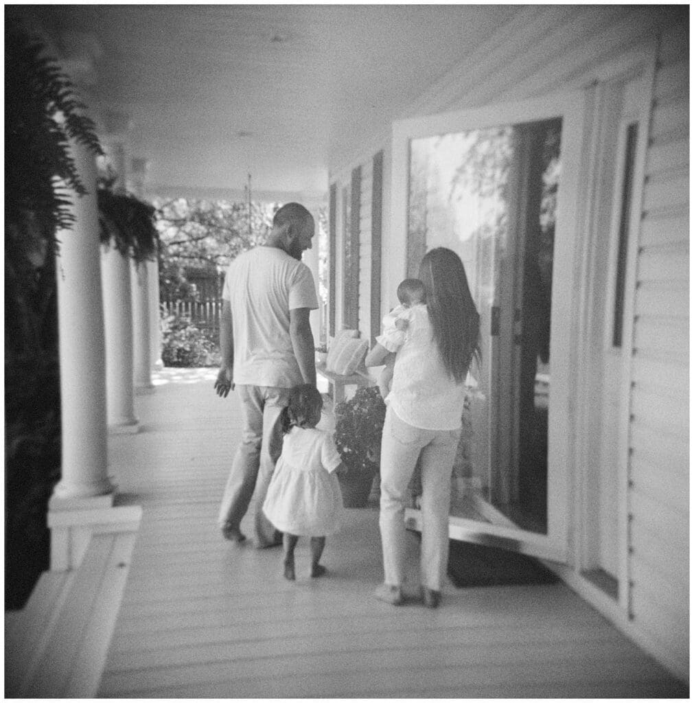 Black and white image of an at home lifestyle newborn session on the family's front porch in Knoxville by Holly Michon Photography.